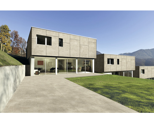 Modernes Haus mit Terrassenplatten und Rasenfläche