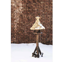 Maison pour oiseaux en bois avec toit de chaume dans un jardin enneigé