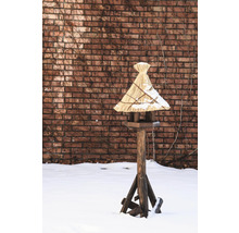 Nichoir avec toit de chaume sur un support en bois dans la neige