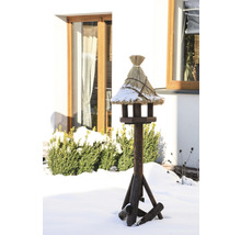 Nichoir en bois avec toit de chaume dans un jardin enneigé
