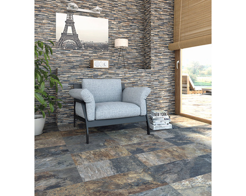 Salon avec fauteuil gris-bleu, papier peint en pierre et carrelage de sol aspect pierre