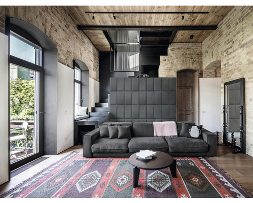 Salon avec canapé, tapis et mur de briques