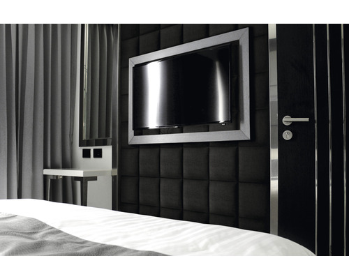 Schlafzimmer mit gepolsterter Wand, Fernseher und Nachttisch