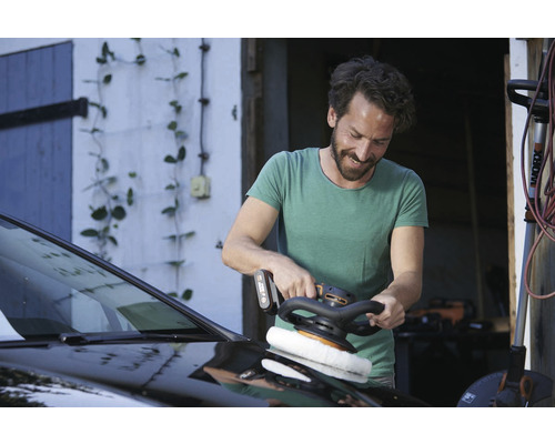 Mann poliert Auto mit Poliermaschine