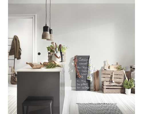 Helle Küche mit Kücheninsel, Hocker, Kreidetafel und Holzkisten als Dekoration.