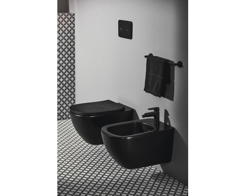 Salle de bains moderne avec WC suspendu et bidet en version foncée, complétée par des carreaux à motifs géométriques.