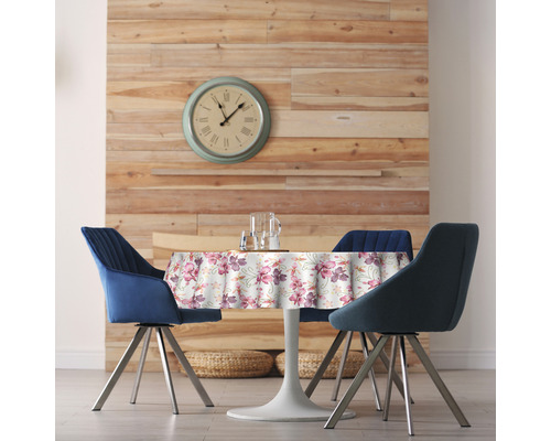 Salle à manger avec table ronde, couverture à fleurs et trois chaises