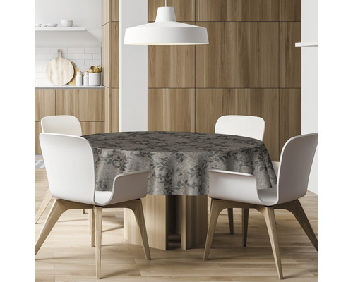 Table de salle à manger ronde avec une nappe à motifs et quatre chaises dans une cuisine.