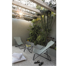 Scène de jardin avec deux chaises longues, table d''appoint et plantes sous une pergola