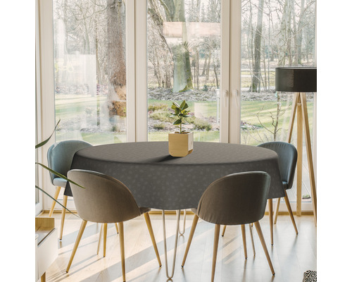 Table à manger avec une nappe grise et des chaises dans une pièce lumineuse