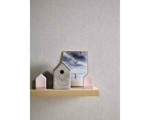 Gros plan d''un papier peint gris avec une structure subtile, visible sur une étagère en bois clair avec des objets de maison décoratifs et une combinaison de presse-papiers photo. La scène dégage une atmosphère calme.