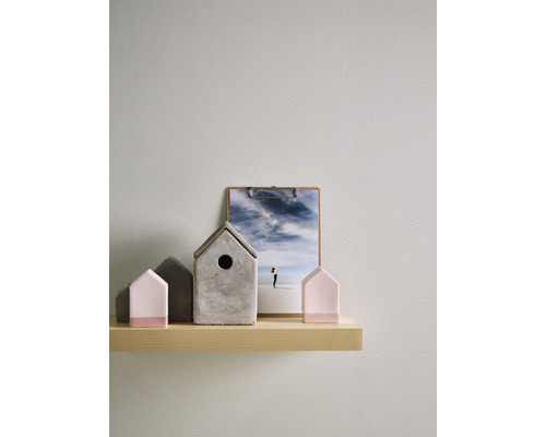Maisons décoratives et photographie sur une étagère devant un mur