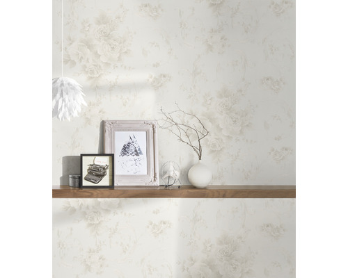 Wohnraum mit Blumentapete, dekoriert mit Bildern, einer Vase und einem Ventilator auf einem Holzregal.