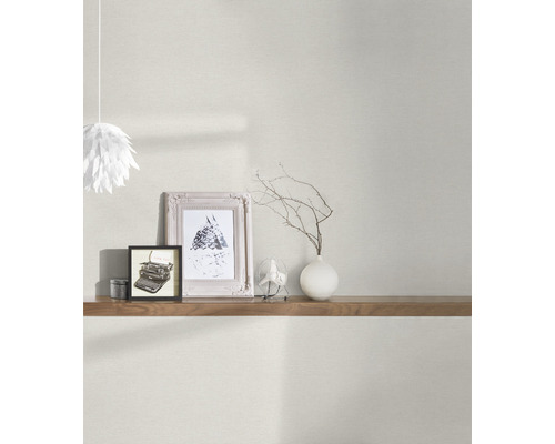 Wohnraumszene mit heller Wandtapete, Regal, Dekorationsartikeln und Lampe
