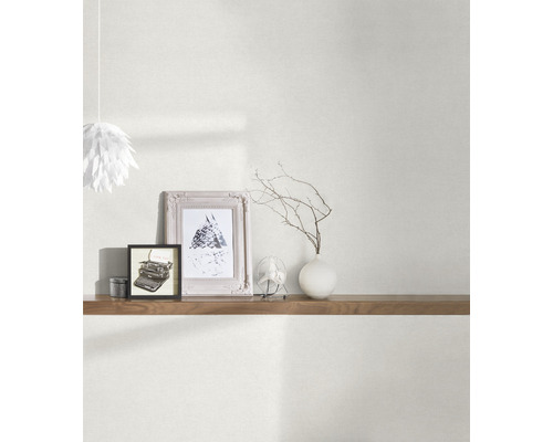 Wohnraum mit Tapete, Regal und dekorativen Elementen wie Bilderrahmen und Vase