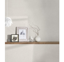 Pièce lumineuse avec papier peint à motifs, étagère en bois, objets de décoration et suspension