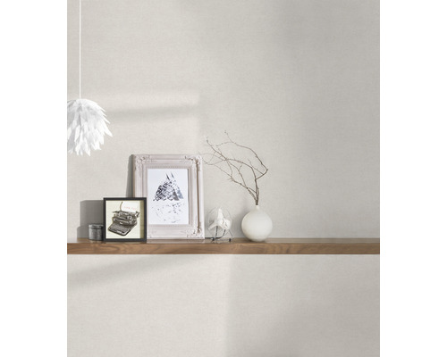 Pièce lumineuse avec papier peint à motifs, étagère en bois, objets de décoration et suspension