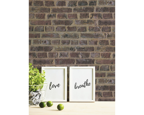 Ziegelwand mit Dekoration, darunter Bilder mit den Aufschriften Liebe und Atmen