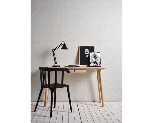 Dekoratives Arbeitszimmer mit Schreibtisch, Stuhl, Lampe und gemusterter Tapete.