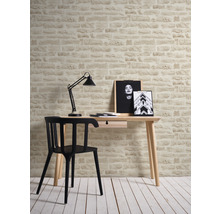 Scène avec bureau, chaise, lampe et mur aspect pierre pour un bureau moderne.