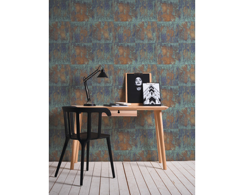 Arbeitszimmer mit Schreibtisch, Stuhl, Lampe und gemusterter Tapete