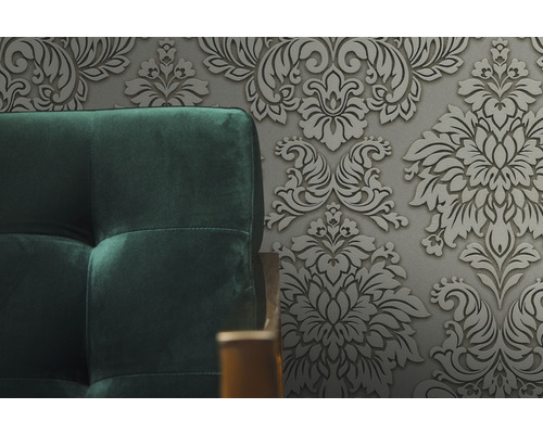 Gros plan d''un canapé rembourré devant un papier peint à motifs floraux