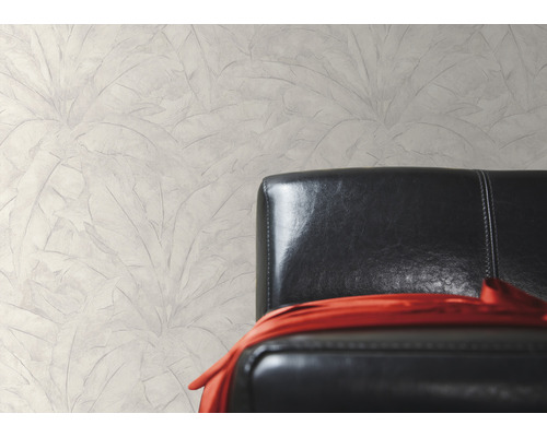 Wandgestaltung mit Blattmuster neben einem schwarzen Ledersessel