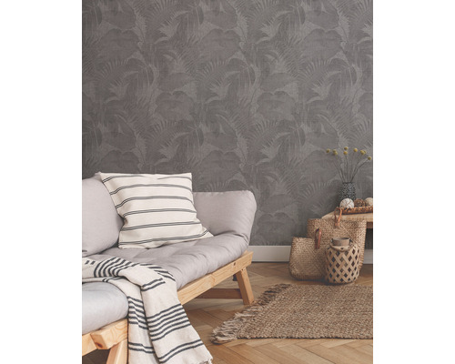 Wohnraum mit grauer Tapete mit Blattmuster, Sofa und Dekorationen