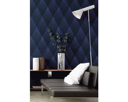 Salon moderne avec papier peint à motif losanges, canapé et objets de décoration.