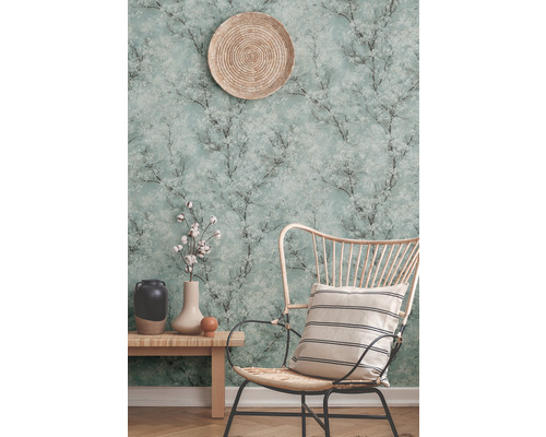 Dekoratives Zimmer mit einer gemusterten Tapete, einem Holzstuhl, einem Beistelltisch und Dekorationsgegenständen