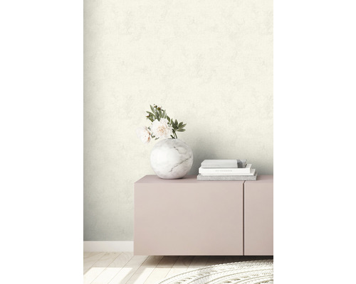 Wand mit gemusterter Tapete, dekoriert mit Blumen in einer Marmorvase und Büchern auf einem Sideboard