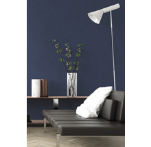 Intérieur moderne avec canapé, lampadaire et objets de décoration devant un mur sombre