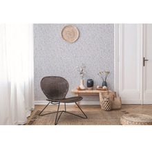 Salon avec papier peint à motifs, fauteuil en rotin et parquet