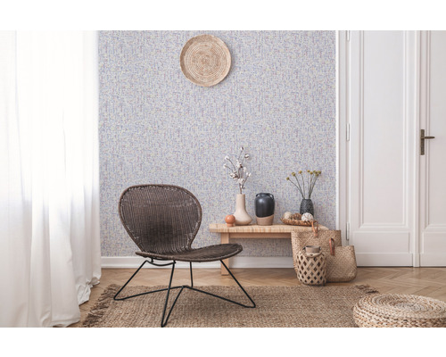 Salon avec papier peint à motifs, fauteuil en rotin et parquet