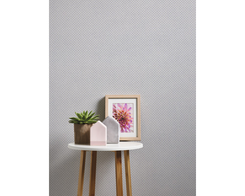 Gros plan d''une petite table avec décoration devant un mur structuré