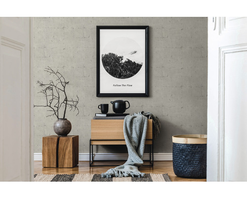 Intérieur avec commode, décoration et image encadrée au mur.