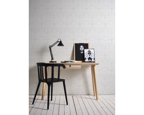 Bureau avec bureau, lampe, chaise et images devant un papier peint à motifs