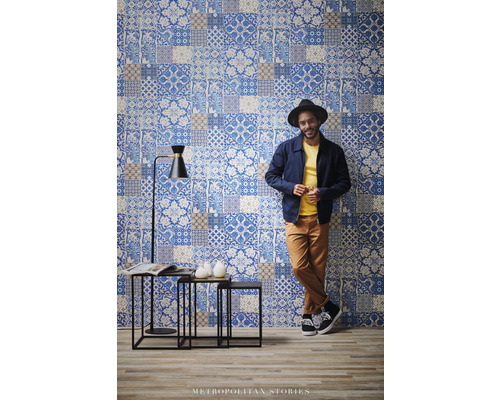 Szene mit einer Wandtapete im Patchwork-Design, einem Beistelltisch-Set und einer Stehlampe.