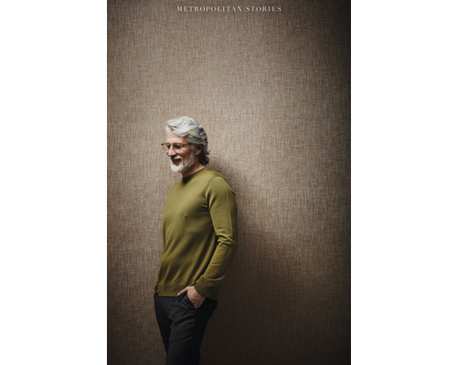 Mann mit Pullover vor einer Wand mit Tapete der Kollektion Metropolitan Stories