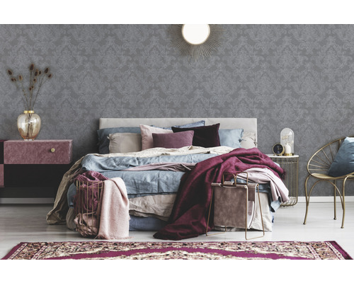 Schlafzimmer mit Bett, Nachttisch, Stuhl und gemusterter Tapete