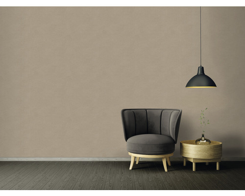 Intérieur avec fauteuil, table d''appoint et suspension devant un mur beige