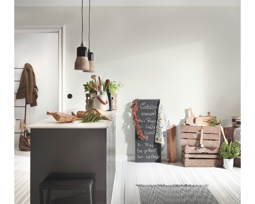 Heller Küchenbereich mit Kücheninsel, dekorativen Elementen und Tafel