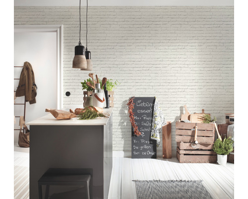 Heller Küchenbereich mit gemauerter Tapete, Kücheninsel und dekorativen Holzkisten