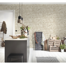 Cuisine lumineuse avec îlot et papier peint imitation pierre pour une ambiance conviviale.