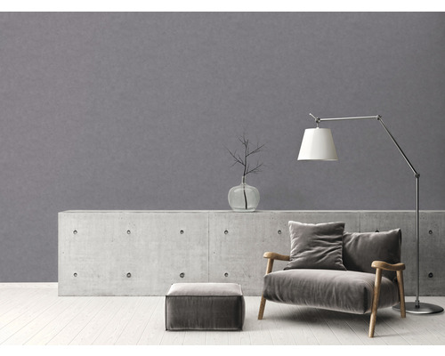 Wohnraum mit grauer Wand, Sessel, Lampe und Dekor