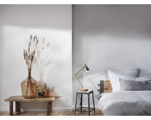 Helles Schlafzimmer mit Bett, Nachttischlampe und Dekoration auf einem Holztisch