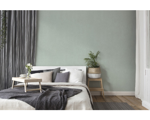 Schlafzimmer mit Bett, Nachttisch, Vorhängen und Zimmerpflanze für eine gemütliche Atmosphäre