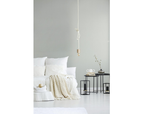 Hell eingerichtetes Schlafzimmer mit Bett, Beistelltischen und Lampe