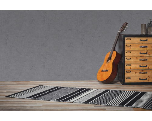 Scène avec un tapis rayé, une guitare et une commode