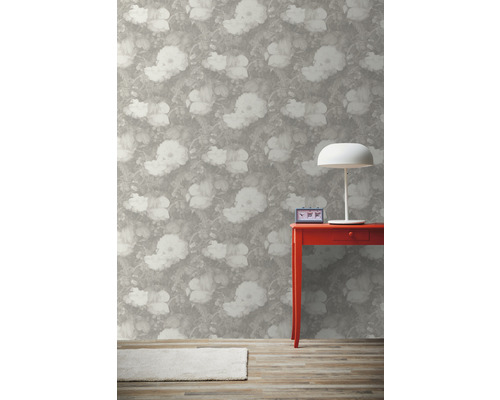 Intérieur avec papier peint fleuri, table rouge, lampe et tapis